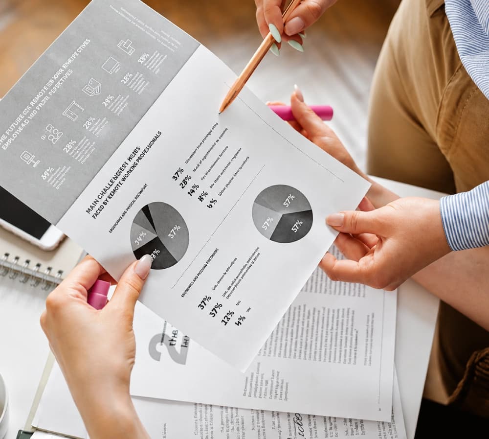 Hands reviewing a printed assessment report with charts and a pencil